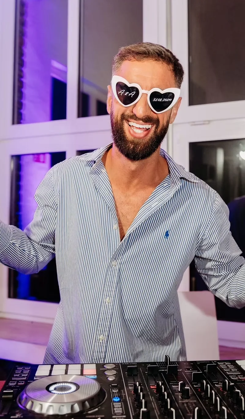 DJ Se7en aus Köln ist am Lachen. Er trägt eine weiße Sonnenbrille